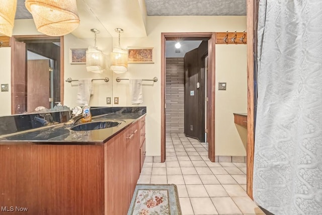 kitchen with pendant lighting, sink, light tile patterned floors, kitchen peninsula, and a chandelier