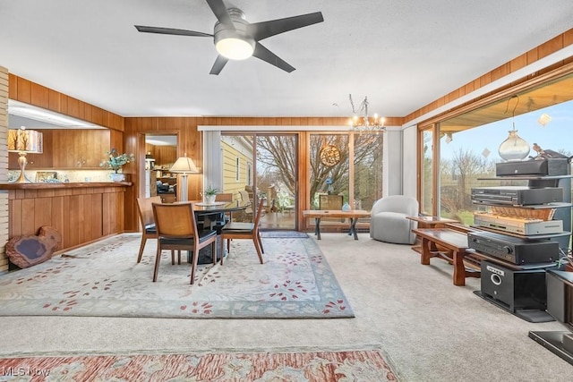 interior space with ceiling fan with notable chandelier