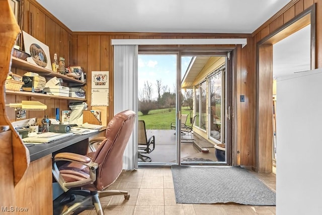 entryway with ornamental molding and wood walls