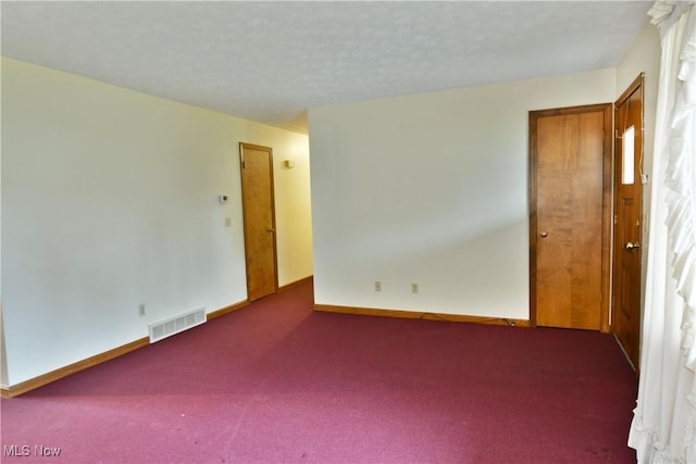 carpeted spare room featuring a textured ceiling