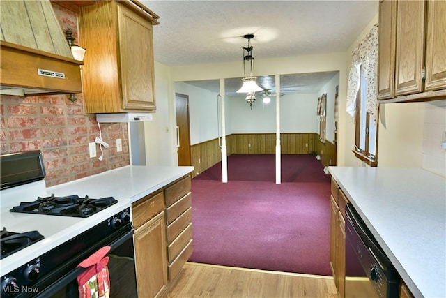 kitchen with hanging light fixtures, light hardwood / wood-style flooring, stainless steel dishwasher, range hood, and white gas range oven