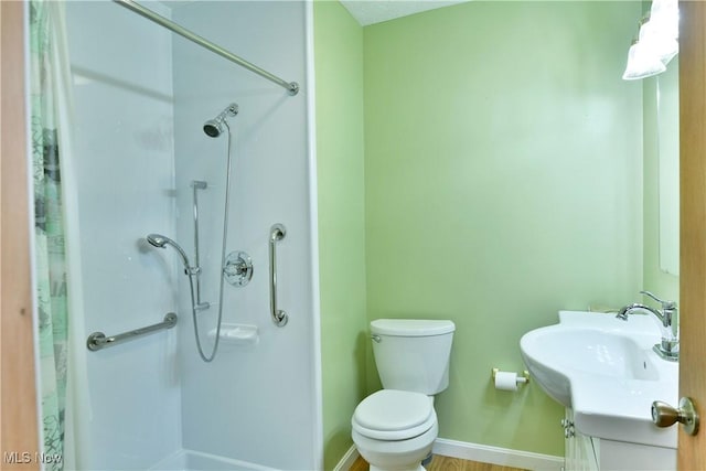 bathroom with hardwood / wood-style flooring, toilet, a shower, and vanity