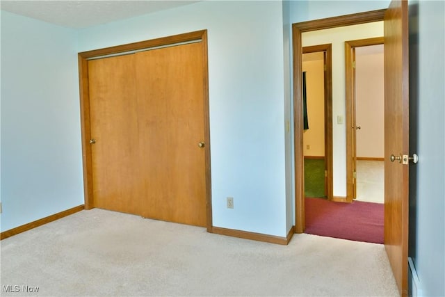 unfurnished bedroom with light carpet and a closet