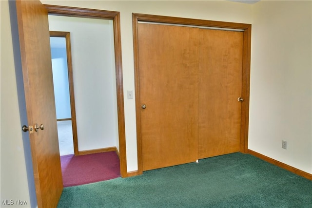 unfurnished bedroom featuring dark carpet and a closet