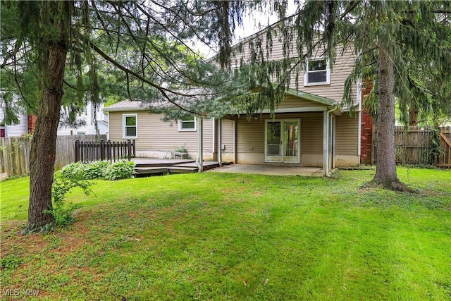 back of property featuring a yard, a deck, and a patio area