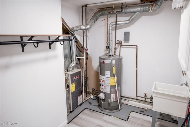 utility room with water heater and sink