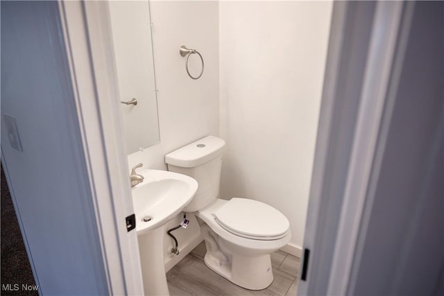 bathroom with wood-type flooring and toilet