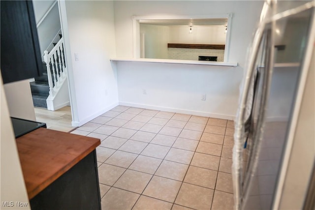 kitchen featuring stainless steel refrigerator and light tile patterned flooring