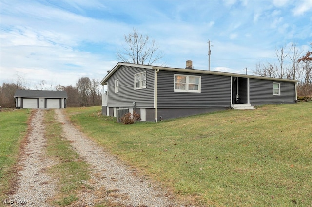 manufactured / mobile home with a garage, an outbuilding, central air condition unit, and a front lawn