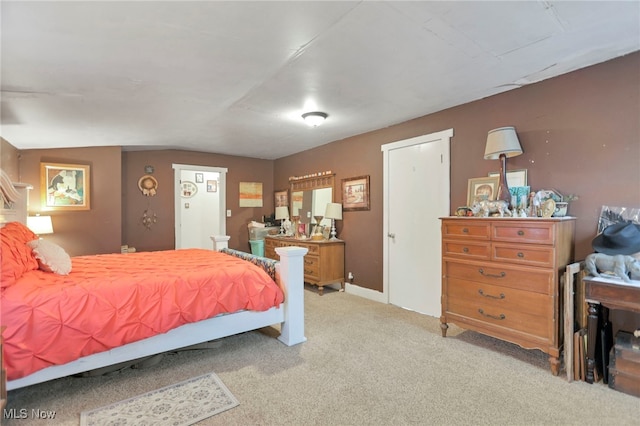 bedroom with light colored carpet and vaulted ceiling