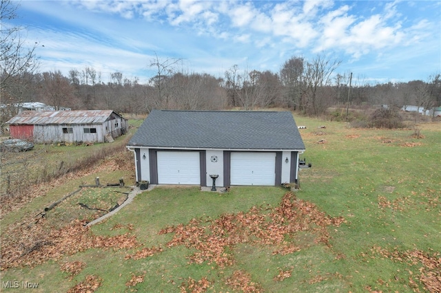 view of outdoor structure featuring a lawn and a garage