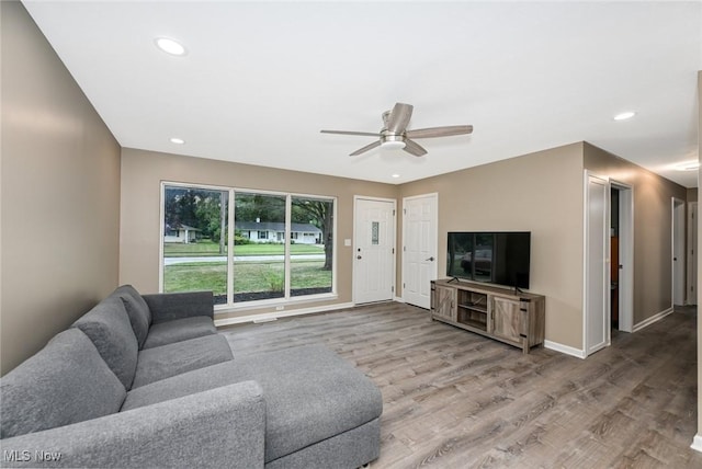 living room featuring ceiling fan and hardwood / wood-style floors