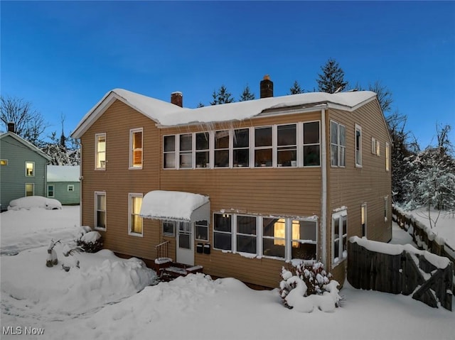 view of snow covered rear of property