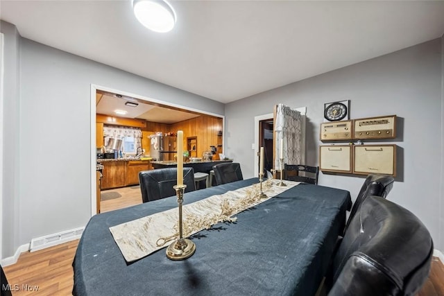 dining area with bar area and light wood-type flooring