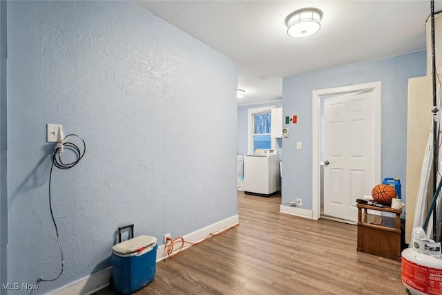 hallway with washer / dryer and wood-type flooring