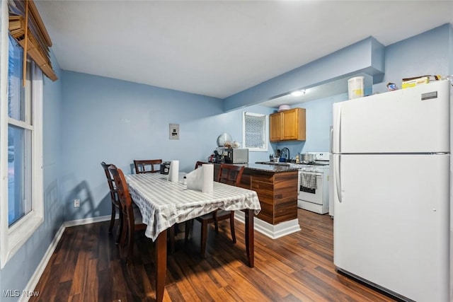 dining space with dark hardwood / wood-style floors and sink