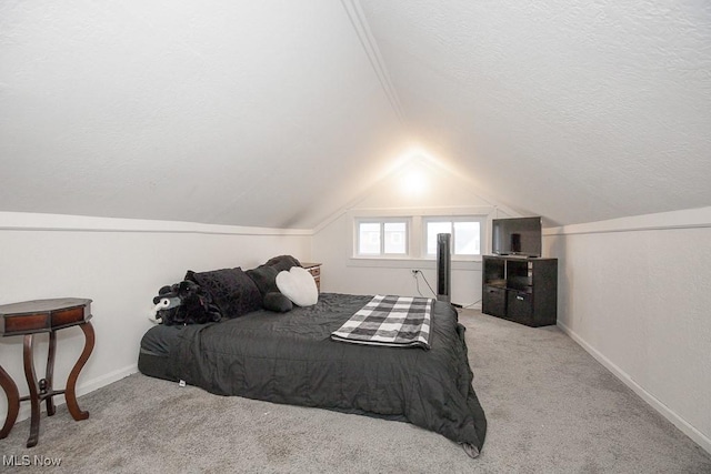 bedroom featuring light colored carpet, lofted ceiling, and a textured ceiling