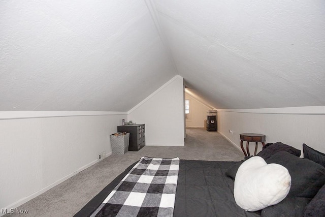 bedroom featuring carpet, a textured ceiling, and vaulted ceiling