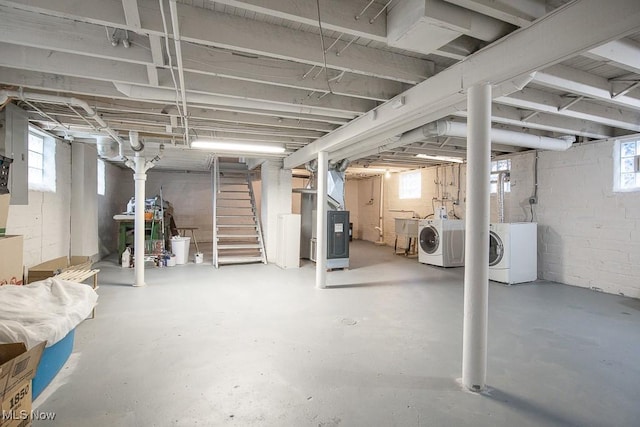 basement featuring heating unit, sink, a wealth of natural light, and washing machine and clothes dryer