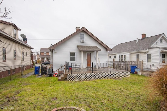 back of property featuring a lawn and a wooden deck