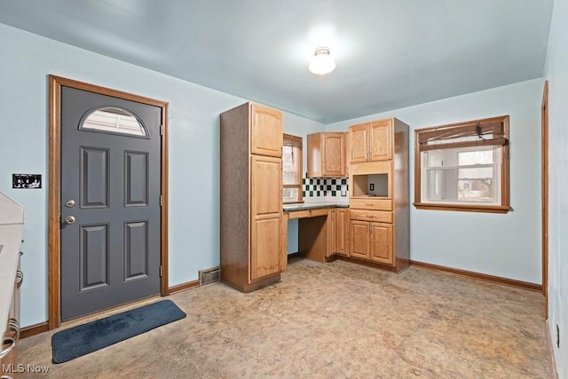 kitchen with backsplash, light brown cabinetry, and light colored carpet