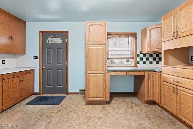 kitchen featuring tasteful backsplash and light carpet