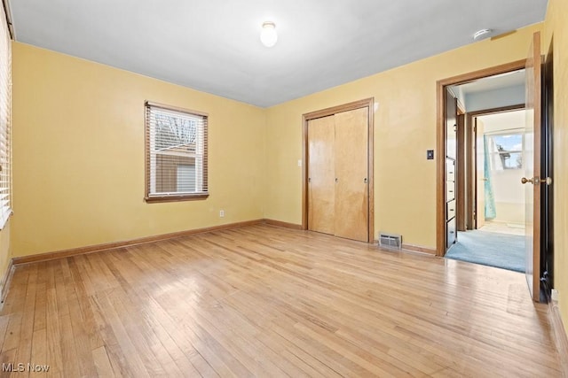 unfurnished bedroom featuring light hardwood / wood-style floors and a closet