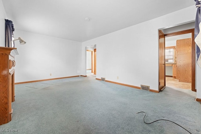 spare room featuring light carpet