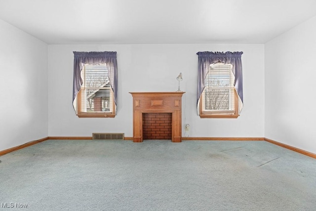 unfurnished living room with carpet flooring and plenty of natural light