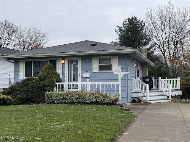 view of front of house with covered porch and a front yard