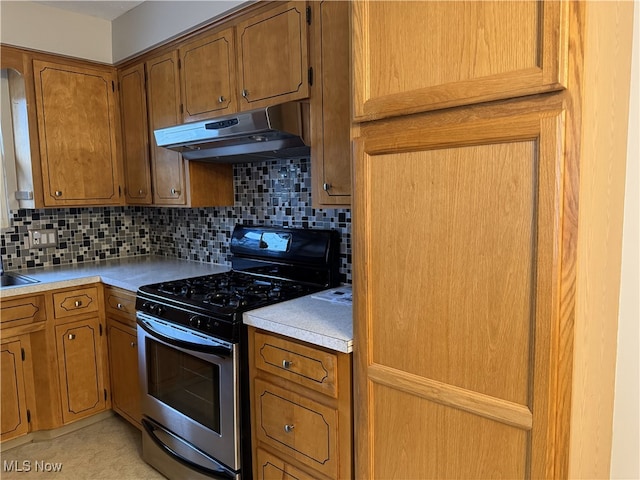 kitchen with sink, stainless steel gas stove, and backsplash