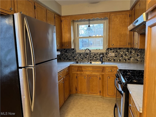 kitchen with pendant lighting, sink, decorative backsplash, range hood, and stainless steel appliances