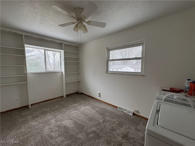 interior space featuring carpet flooring, ceiling fan, washer / dryer, and multiple windows