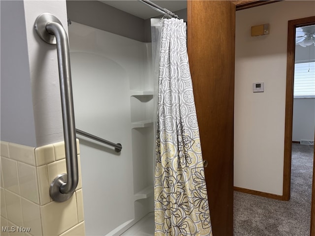 bathroom featuring curtained shower and ceiling fan