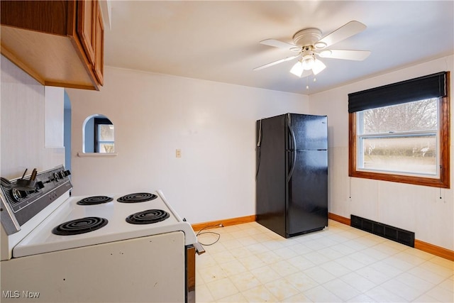 kitchen with electric stove, ceiling fan, and black refrigerator