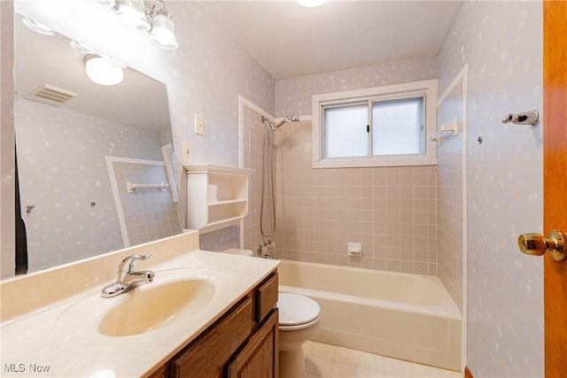 full bathroom with vanity, toilet, and tiled shower / bath combo