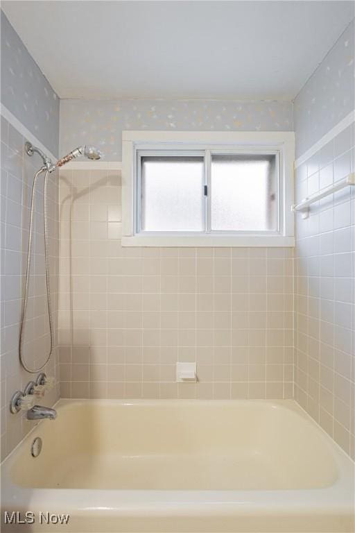 bathroom featuring plenty of natural light and tiled shower / bath