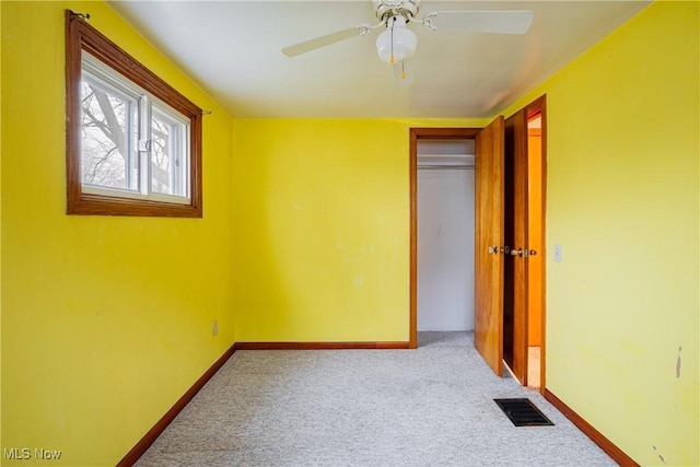 unfurnished bedroom featuring light carpet, a closet, and ceiling fan