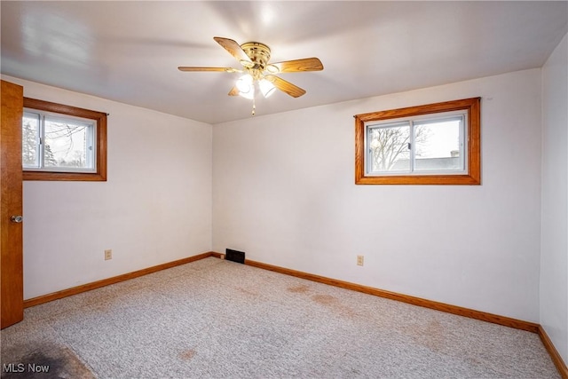 carpeted empty room featuring ceiling fan and a healthy amount of sunlight