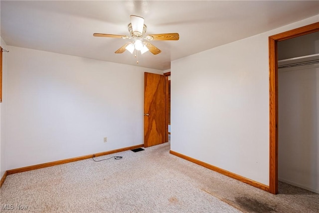 unfurnished bedroom with light carpet, a closet, and ceiling fan