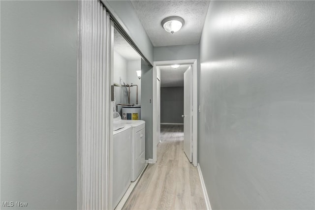 hallway with light hardwood / wood-style floors and independent washer and dryer