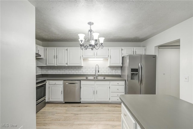 kitchen with sink, white cabinets, stainless steel appliances, and light hardwood / wood-style flooring