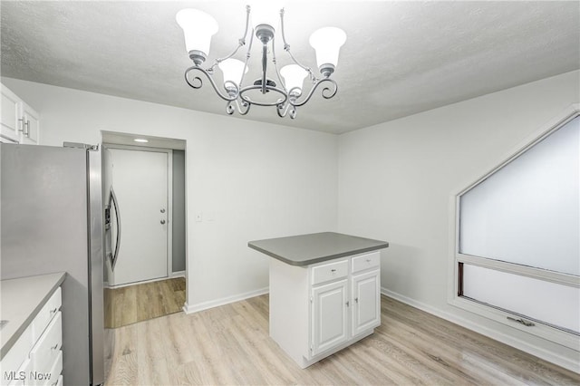 kitchen featuring white cabinetry, an inviting chandelier, light hardwood / wood-style flooring, stainless steel refrigerator with ice dispenser, and decorative light fixtures