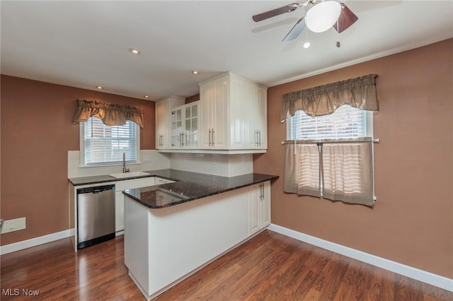 kitchen with kitchen peninsula, dark hardwood / wood-style flooring, white cabinets, and stainless steel dishwasher