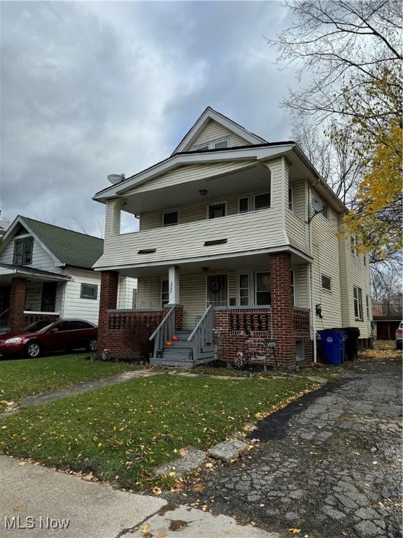 front facade with a front lawn and covered porch