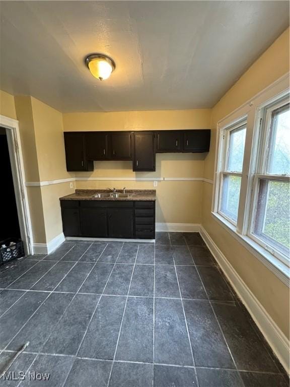 kitchen featuring dark tile patterned flooring and sink