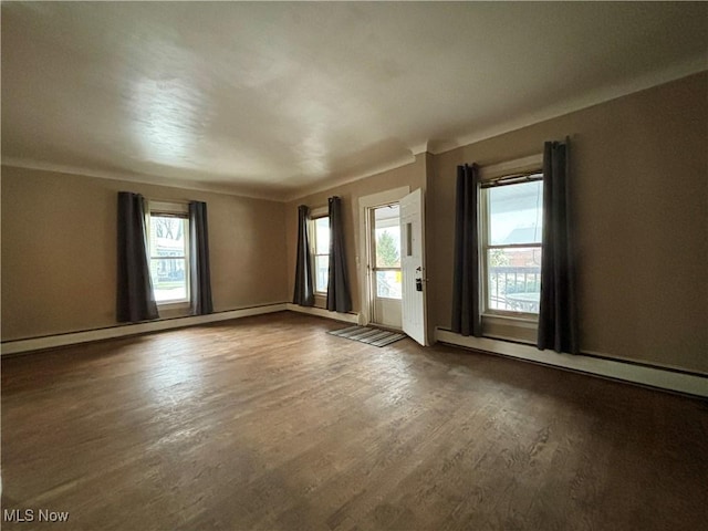 spare room with dark hardwood / wood-style floors and baseboard heating