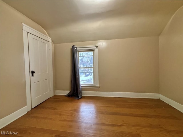 bonus room with hardwood / wood-style floors and lofted ceiling