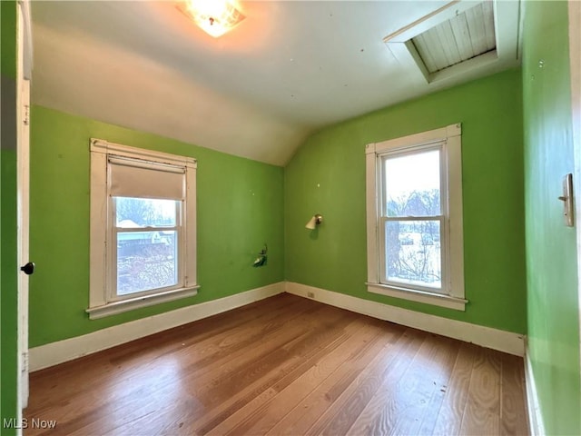 additional living space with hardwood / wood-style floors and lofted ceiling