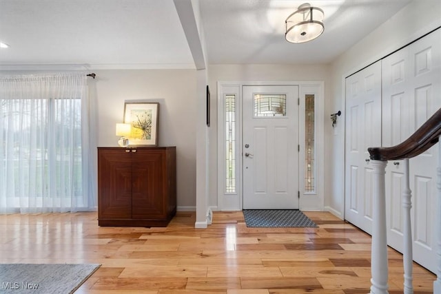 entrance foyer featuring light hardwood / wood-style floors and ornamental molding